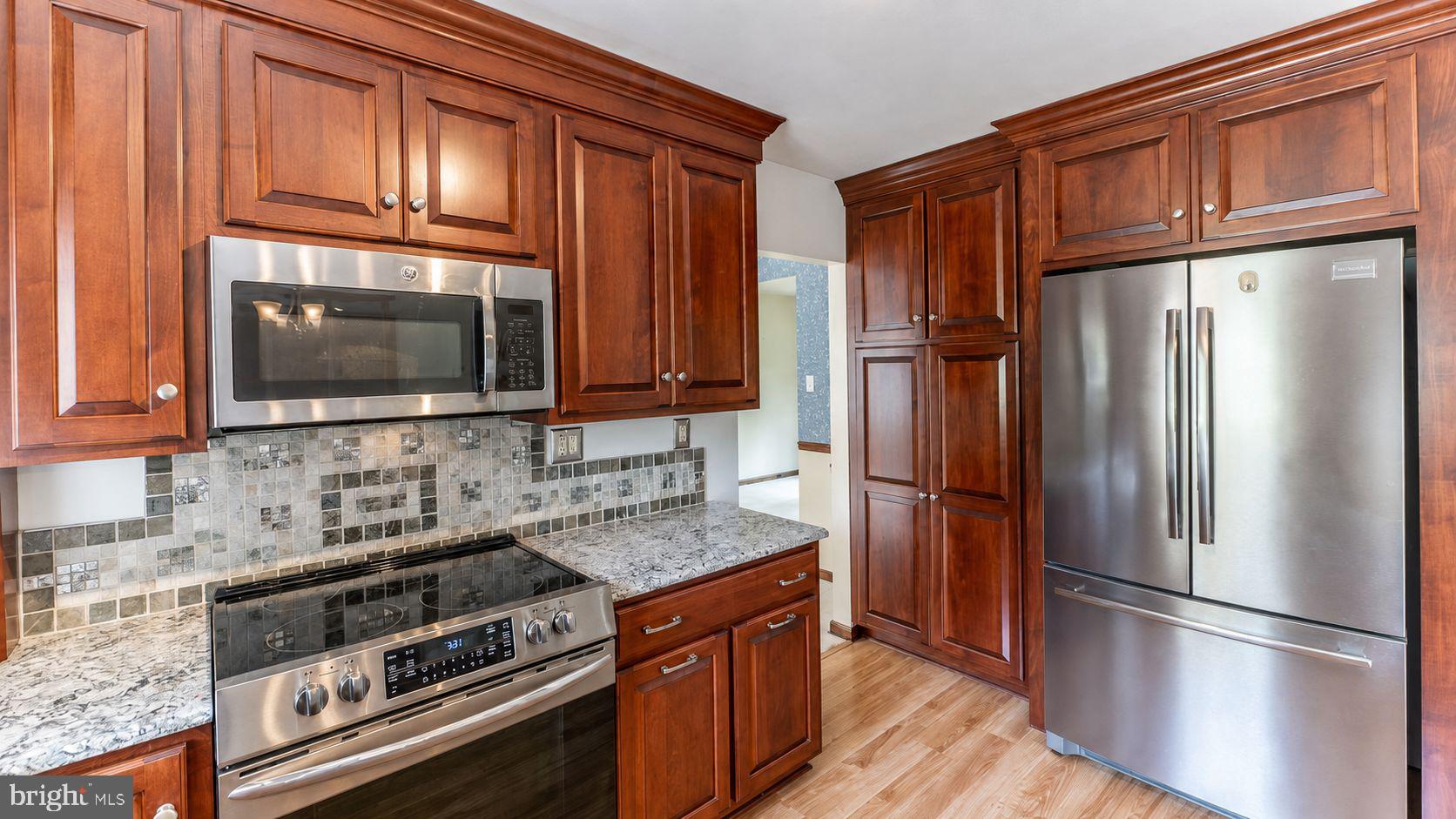 223 Trythall Road Elverson, PA 19520 - Photo 25 of 78 a kitchen with granite countertop a refrigerator stove and microwave