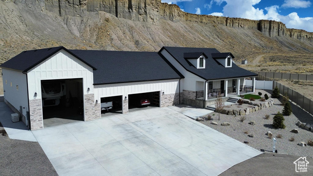 1240 West 2360 North Helper, UT 84526 - Photo 77 of 79 Modern inspired farmhouse featuring covered porch, stone siding, fence, board and batten siding, and a garage