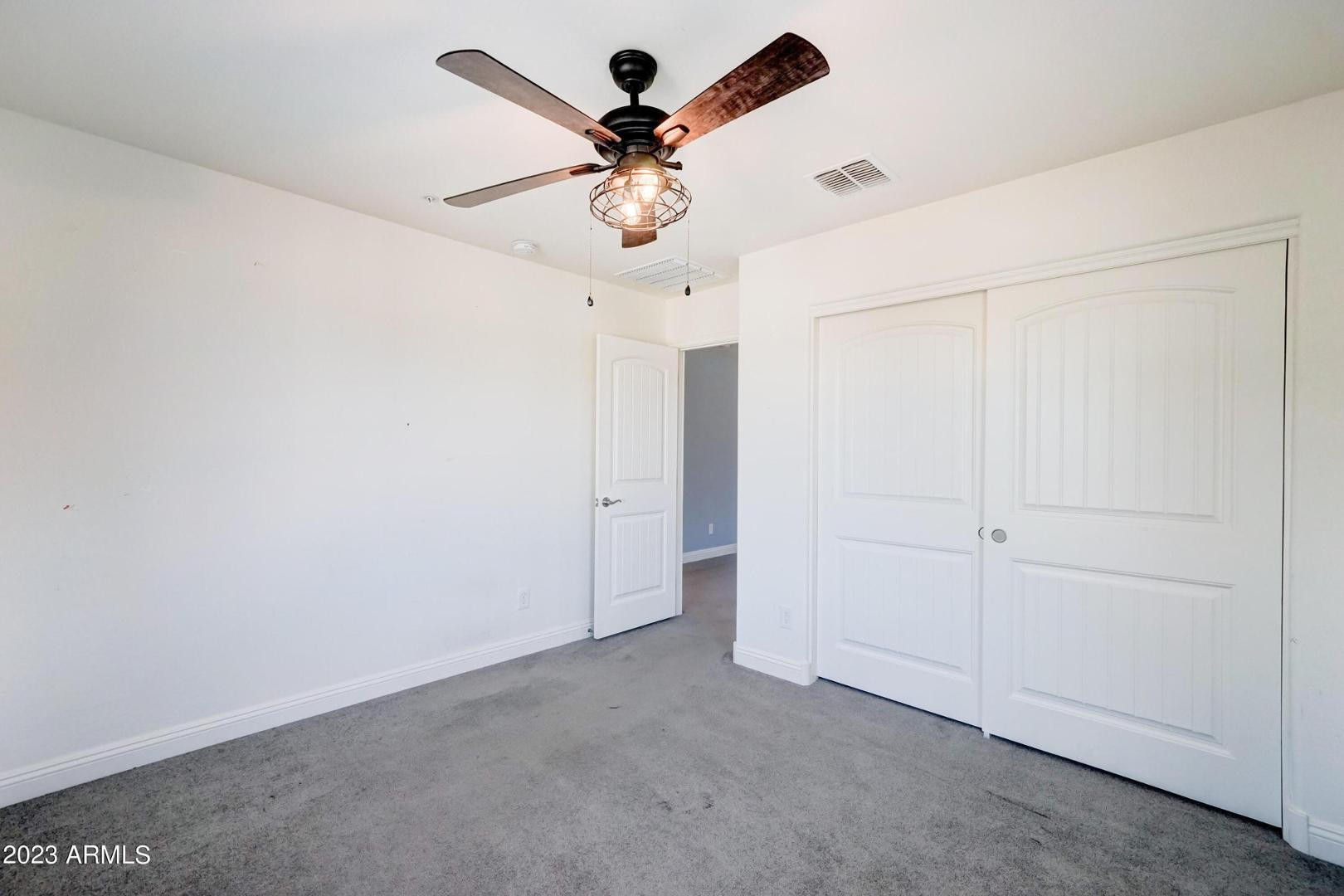 2297 North Alsap Road Buckeye, AZ 85396 - Photo 20 of 36 an empty room with closet and a chandelier fan
