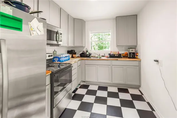 a kitchen with a sink a stove a microwave and cabinets