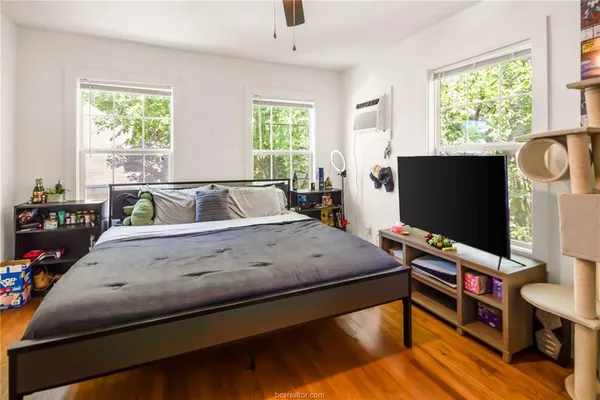 a bedroom with a bed window and flat screen tv