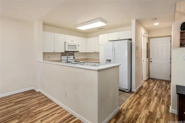 a kitchen with kitchen island a sink appliances and cabinets