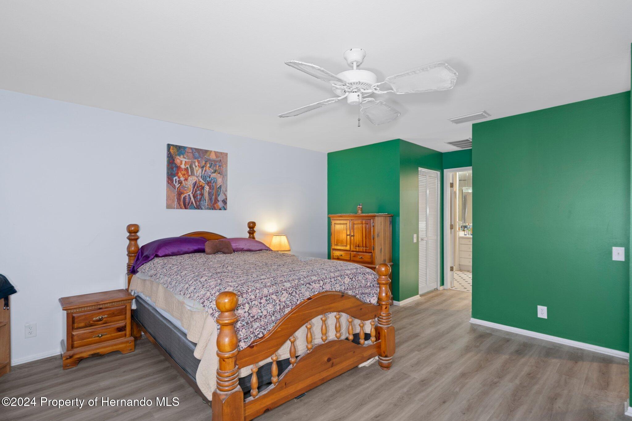 3160 Whispering Pines Court Spring Hill, FL 34606 - Photo 16 of 37 a bedroom with a bed and a chandelier