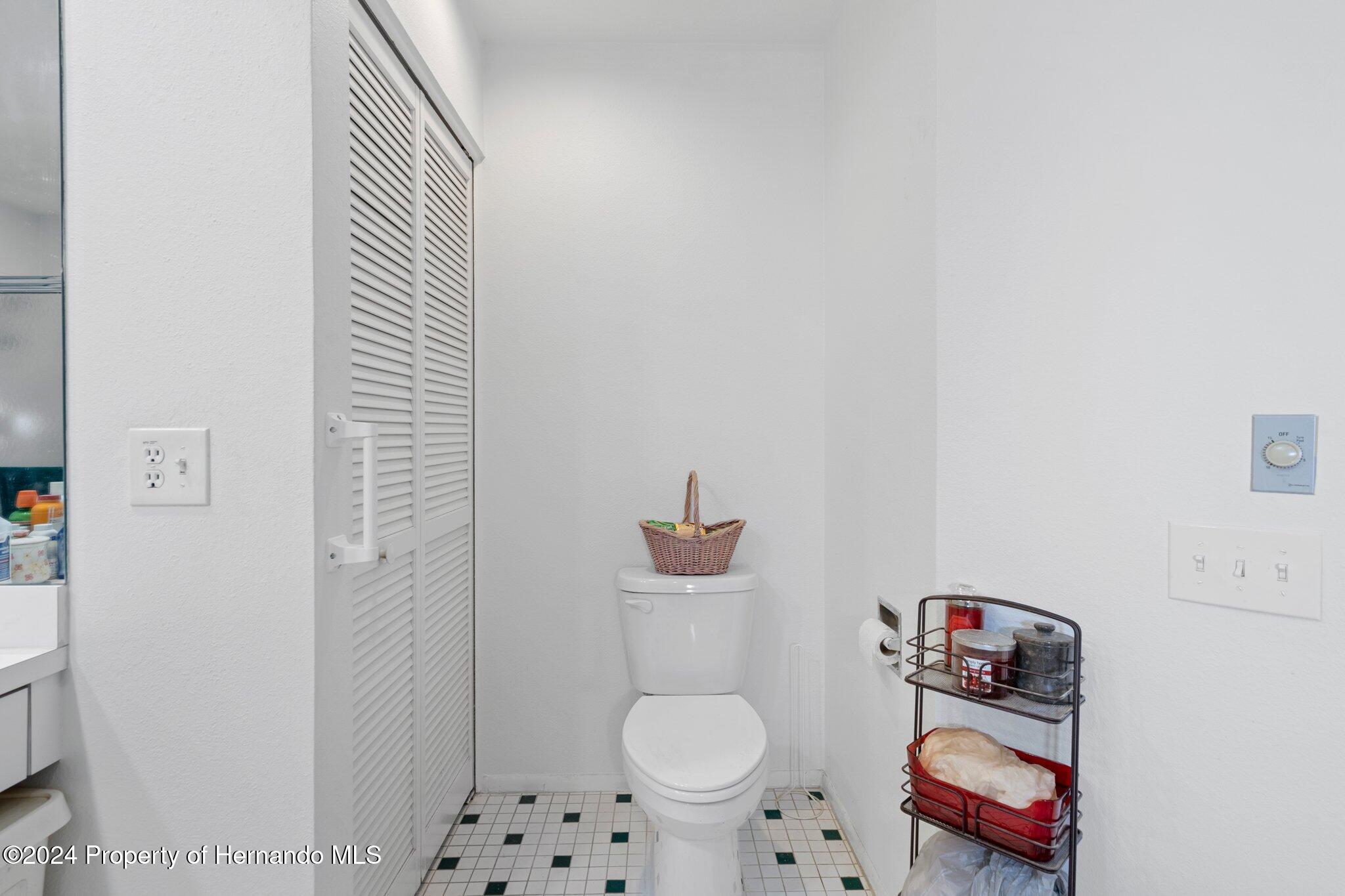 3160 Whispering Pines Court Spring Hill, FL 34606 - Photo 19 of 37 a bathroom with a toilet and a shower curtain