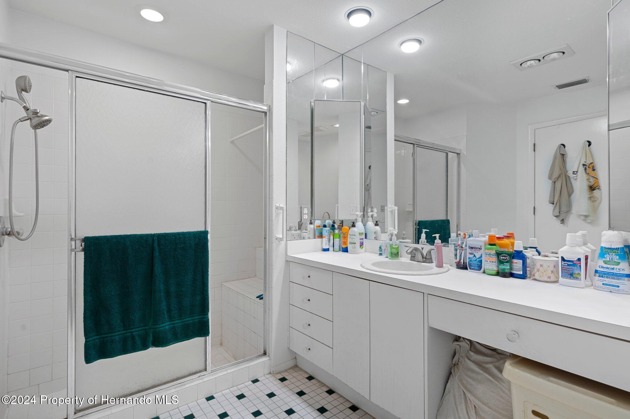 3160 Whispering Pines Court Spring Hill, FL 34606 - Photo 20 of 37 a bathroom with a shower sink and mirror