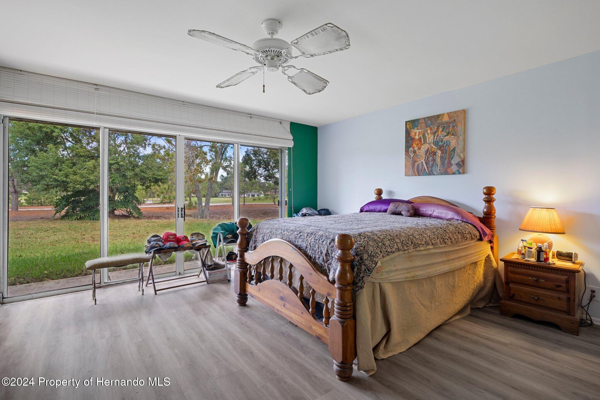 3160 Whispering Pines Court Spring Hill, FL 34606 - Photo 25 of 37 a spacious bedroom with a bed a table and a large window