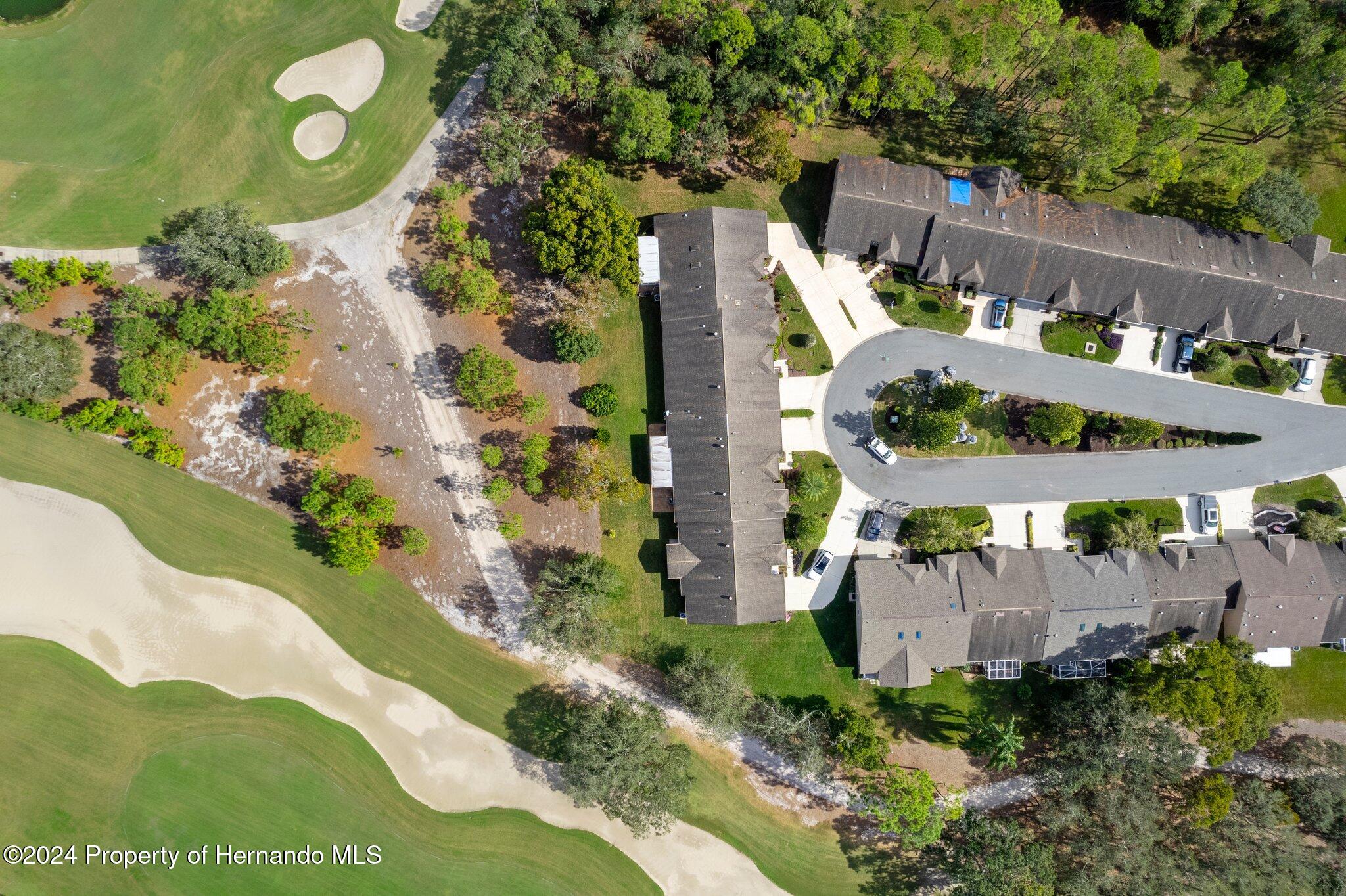 3160 Whispering Pines Court Spring Hill, FL 34606 - Photo 36 of 37 a view of a house with a swimming pool and a yard