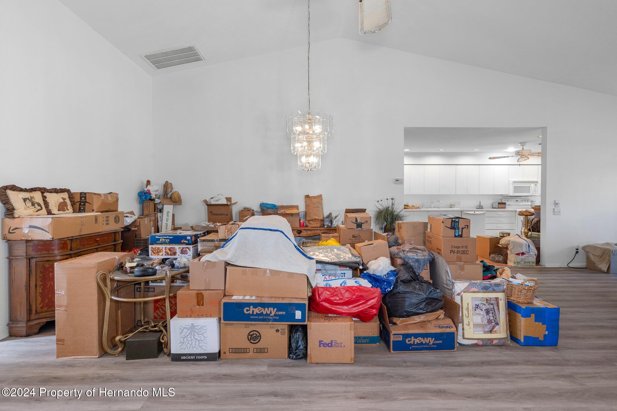 3160 Whispering Pines Court Spring Hill, FL 34606 - Photo 6 of 37 a room with gym equipment and a chandelier