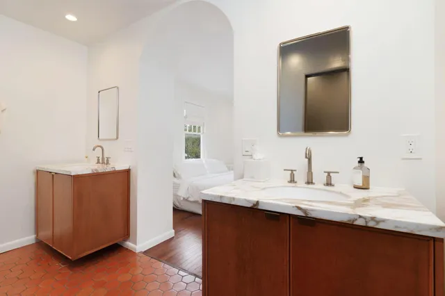 a bathroom with a granite countertop sink and a mirror