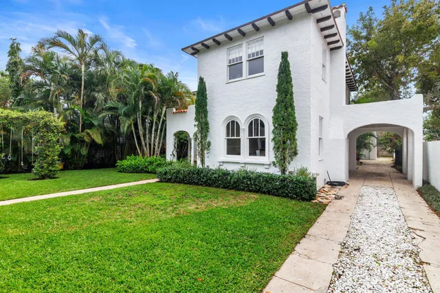 a view of a white house with a yard and plants