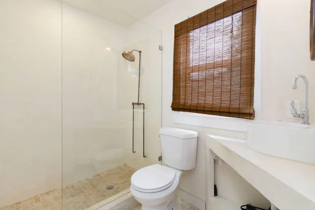 a white toilet sitting next to a bathroom sink