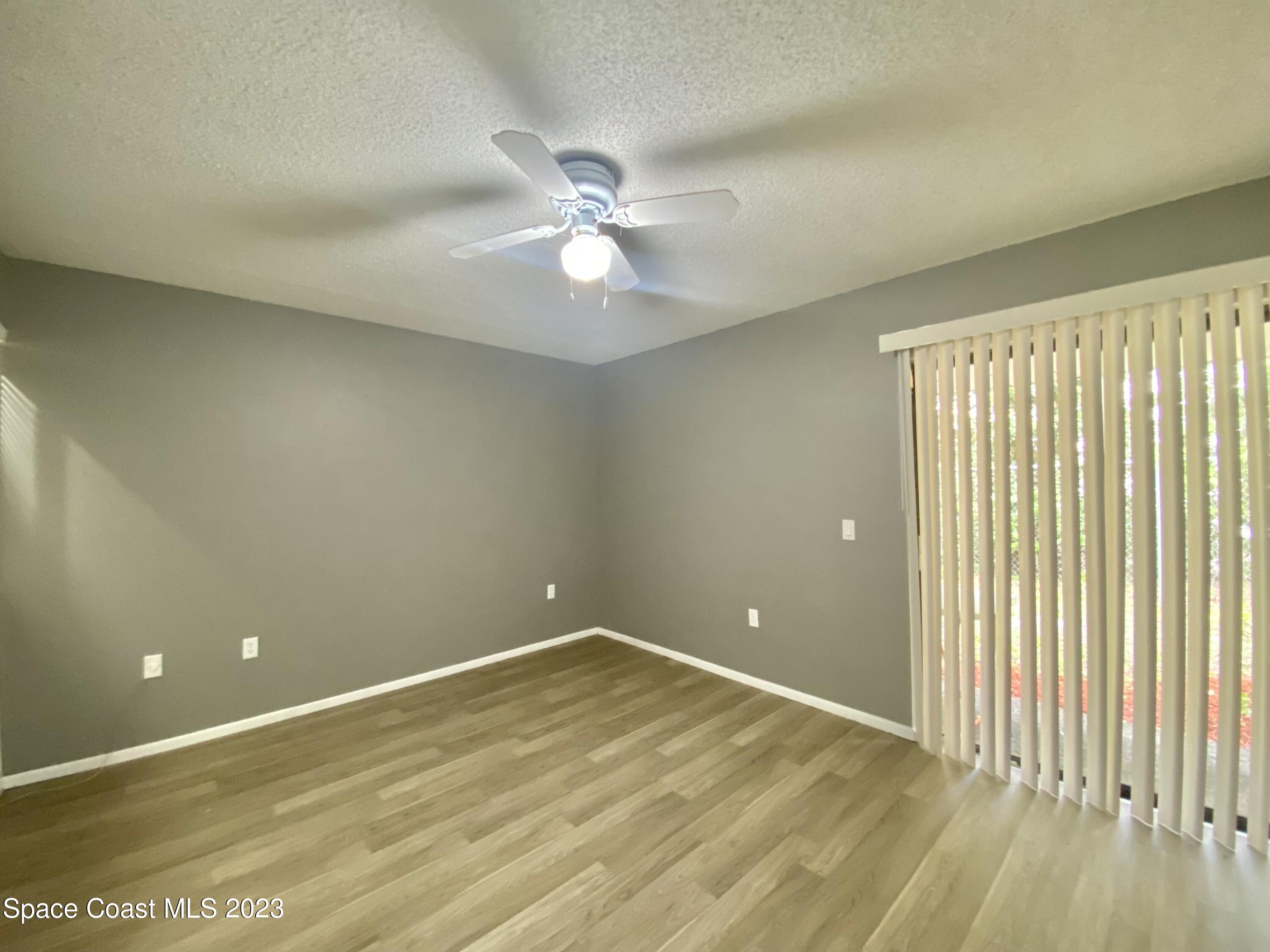 664 Cedar Side Circle Northeast Palm Bay, FL 32905 - Photo 11 of 20 wooden floor in an empty room with a window