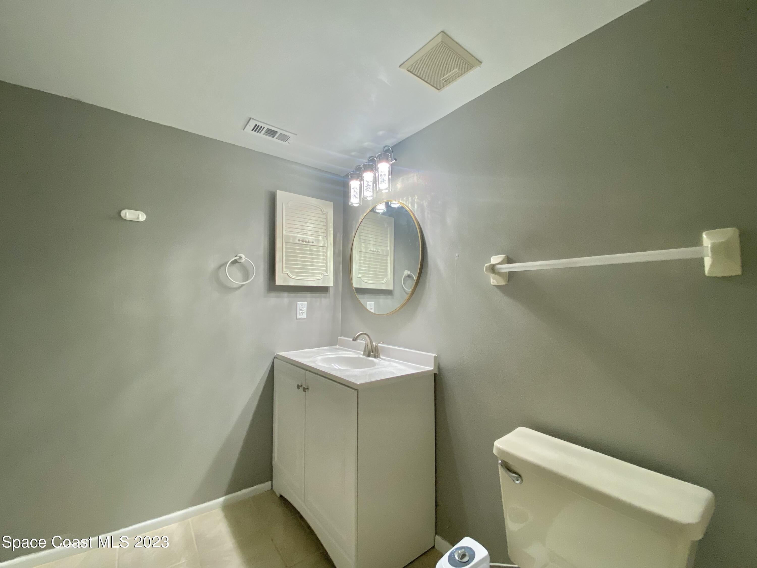 664 Cedar Side Circle Northeast Palm Bay, FL 32905 - Photo 17 of 20 a bathroom with a sink toilet and mirror