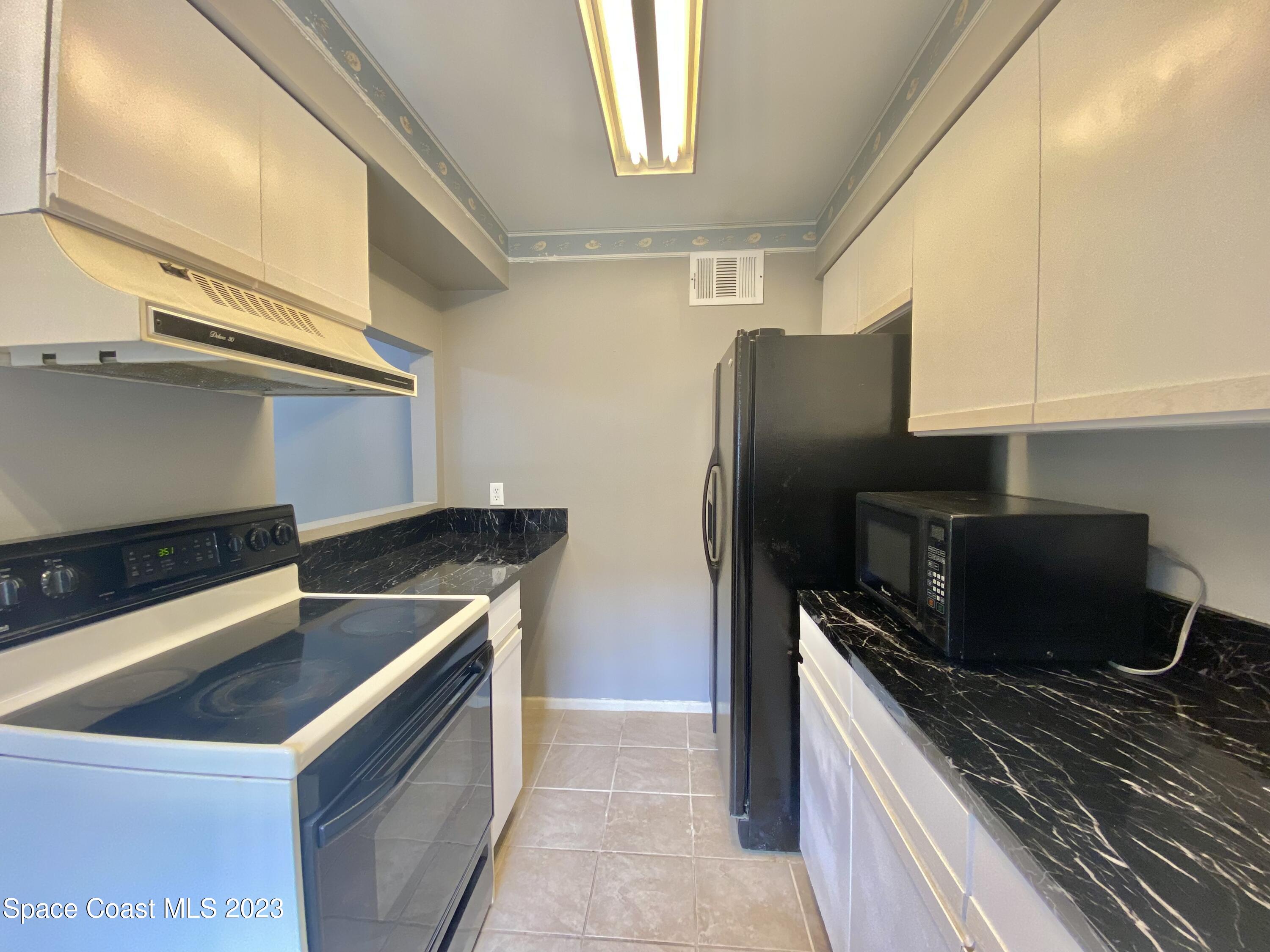 664 Cedar Side Circle Northeast Palm Bay, FL 32905 - Photo 3 of 20 a kitchen with a refrigerator and a sink
