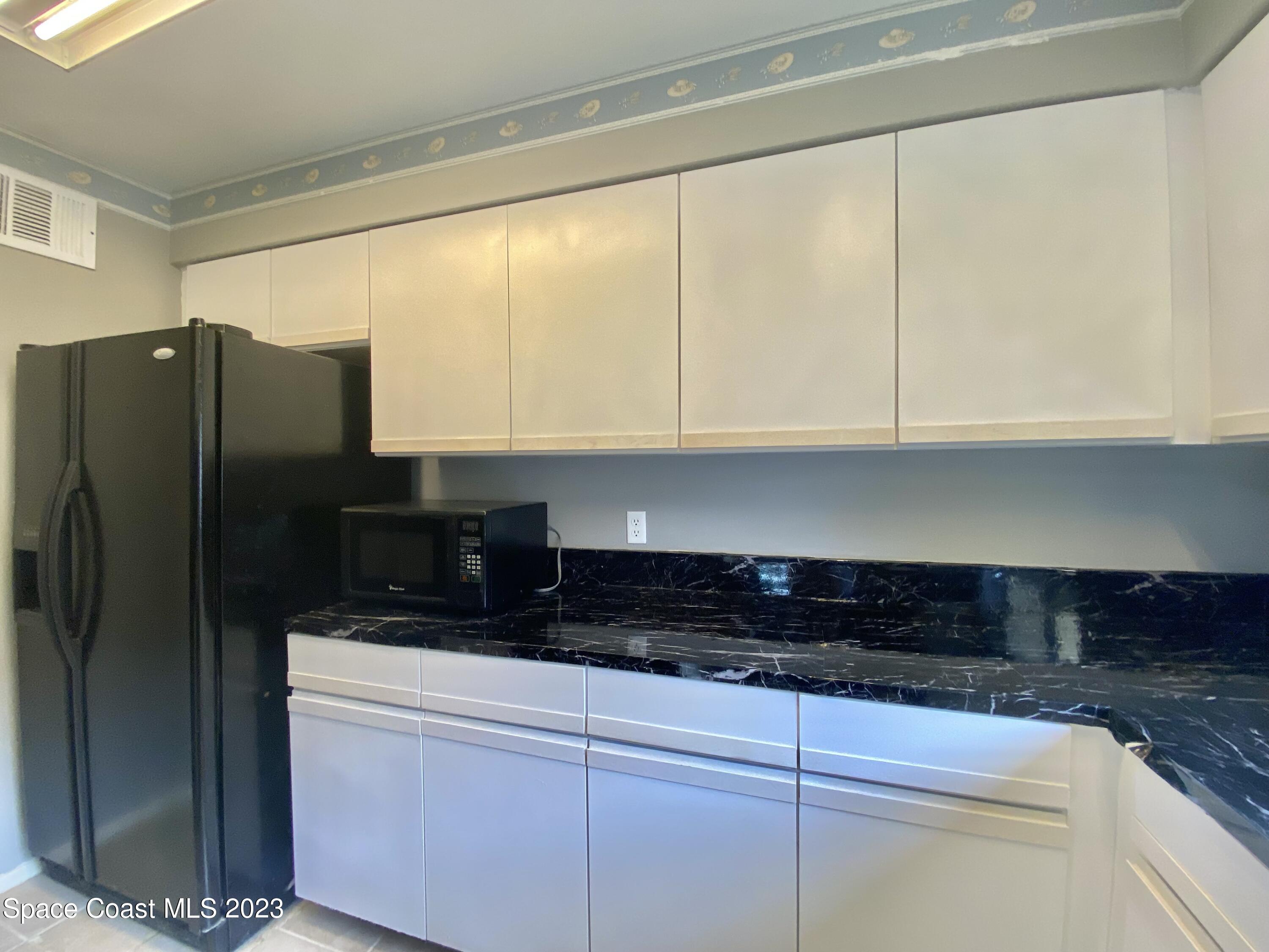 664 Cedar Side Circle Northeast Palm Bay, FL 32905 - Photo 5 of 20 a kitchen with stainless steel appliances granite countertop a refrigerator and cabinets