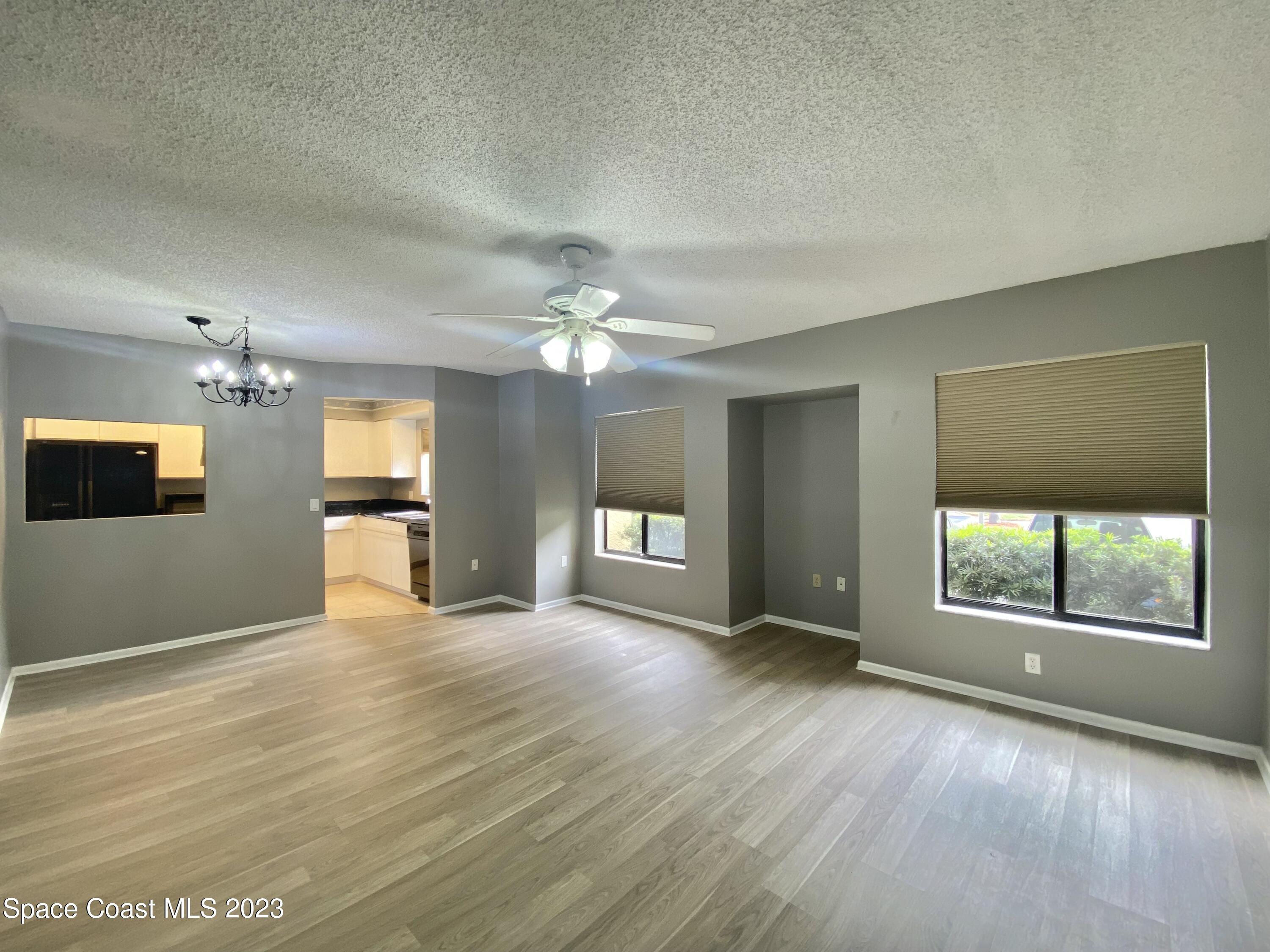 664 Cedar Side Circle Northeast Palm Bay, FL 32905 - Photo 6 of 20 a view of an empty room with a window and wooden floor