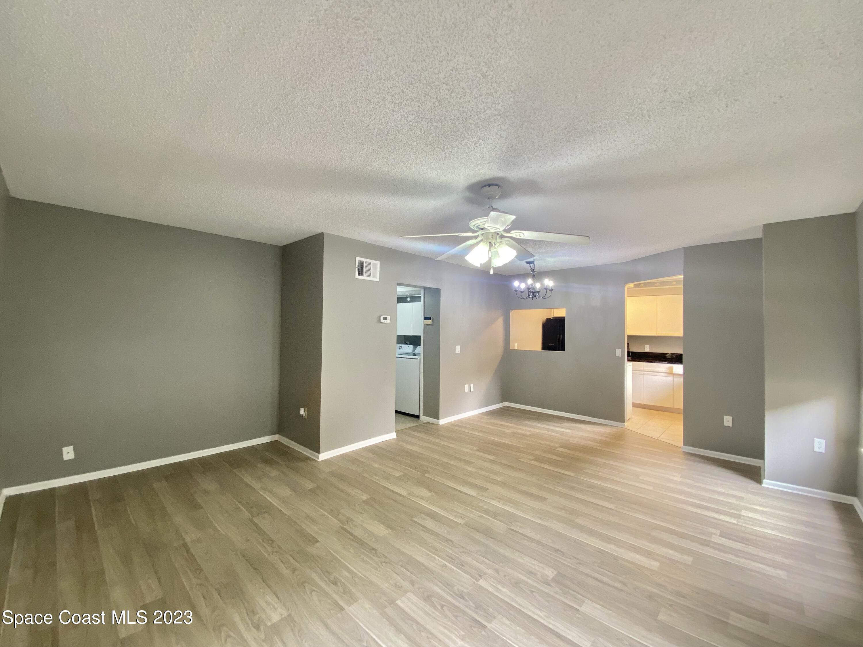 664 Cedar Side Circle Northeast Palm Bay, FL 32905 - Photo 7 of 20 a view of an empty room with window and wooden floor