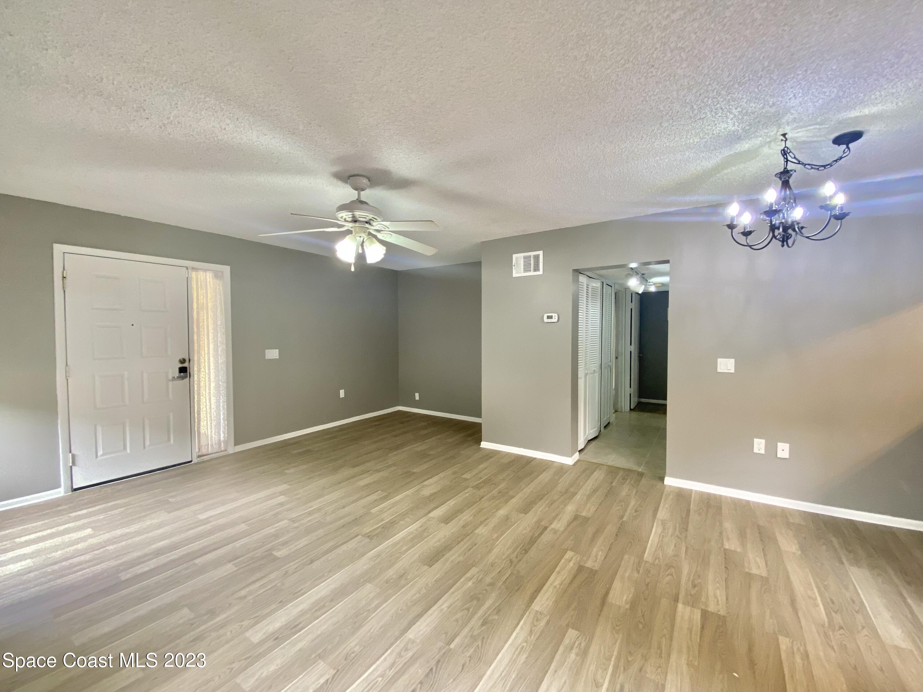 664 Cedar Side Circle Northeast Palm Bay, FL 32905 - Photo 8 of 20 wooden floor in an empty room with a window