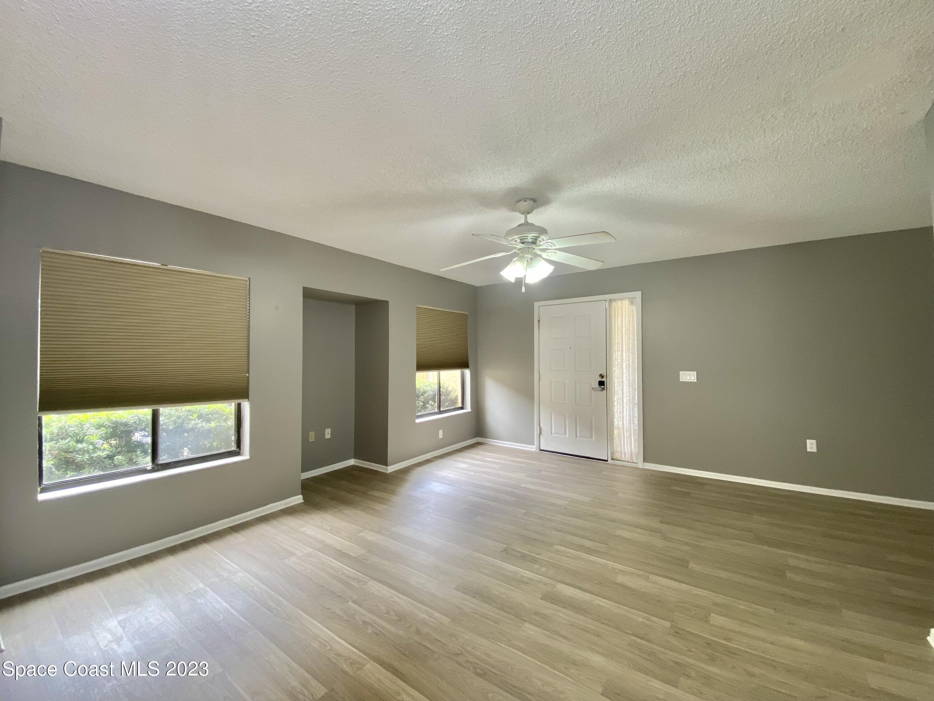 664 Cedar Side Circle Northeast Palm Bay, FL 32905 - Photo 9 of 20 a view of an empty room with a window and wooden floor