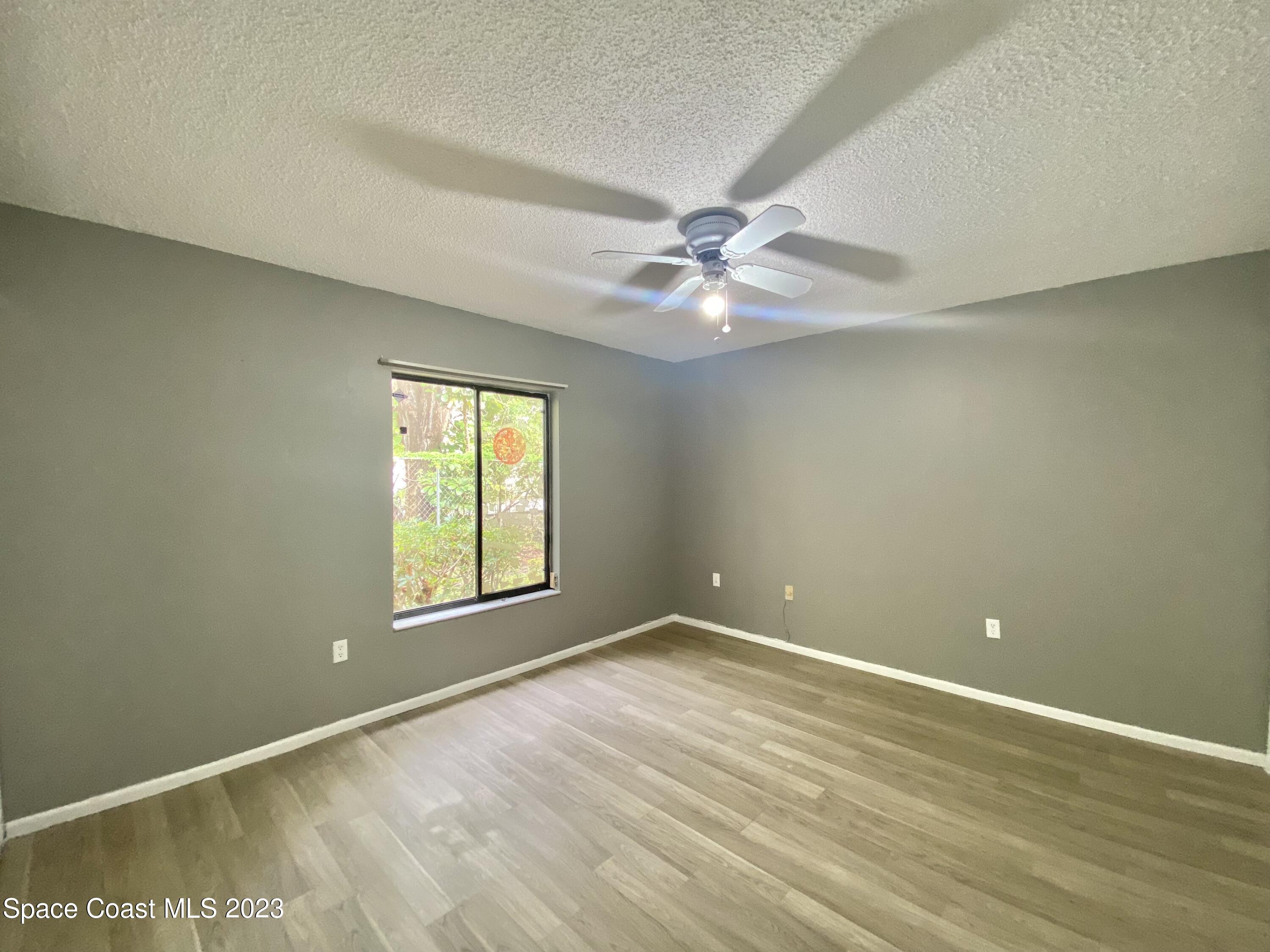 664 Cedar Side Circle Northeast Palm Bay, FL 32905 - Photo 10 of 20 wooden floor in an empty room with a window
