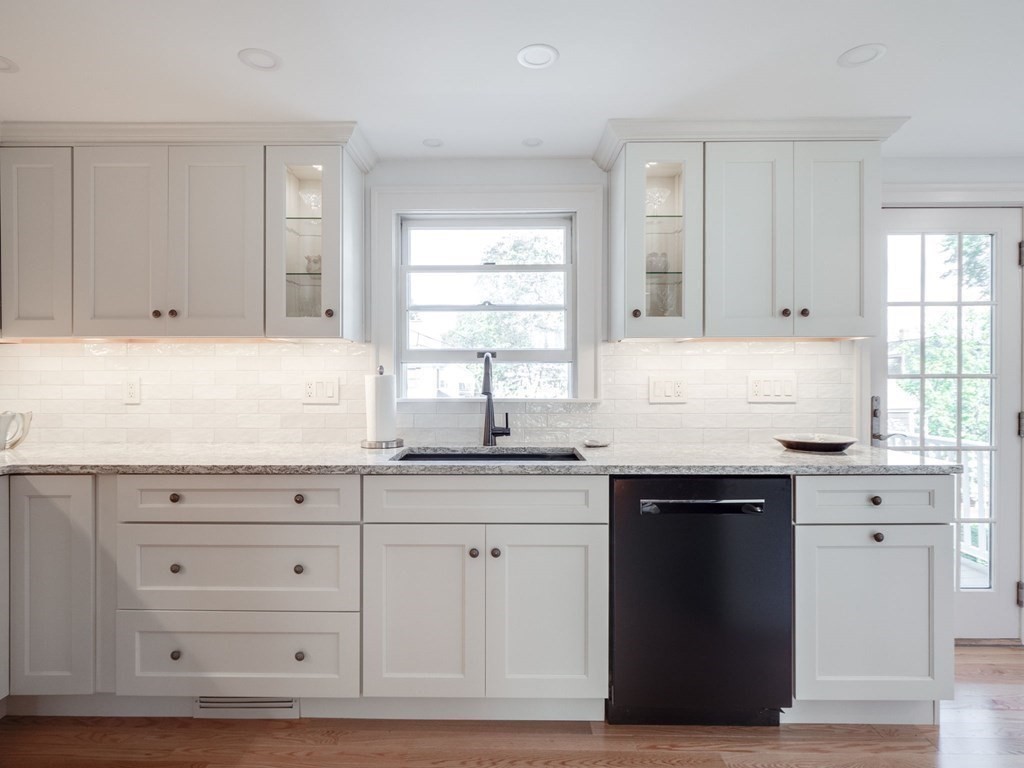35 Pine Street Melrose, MA 02176 - Photo 4 of 38 a kitchen with granite countertop white cabinets and sink