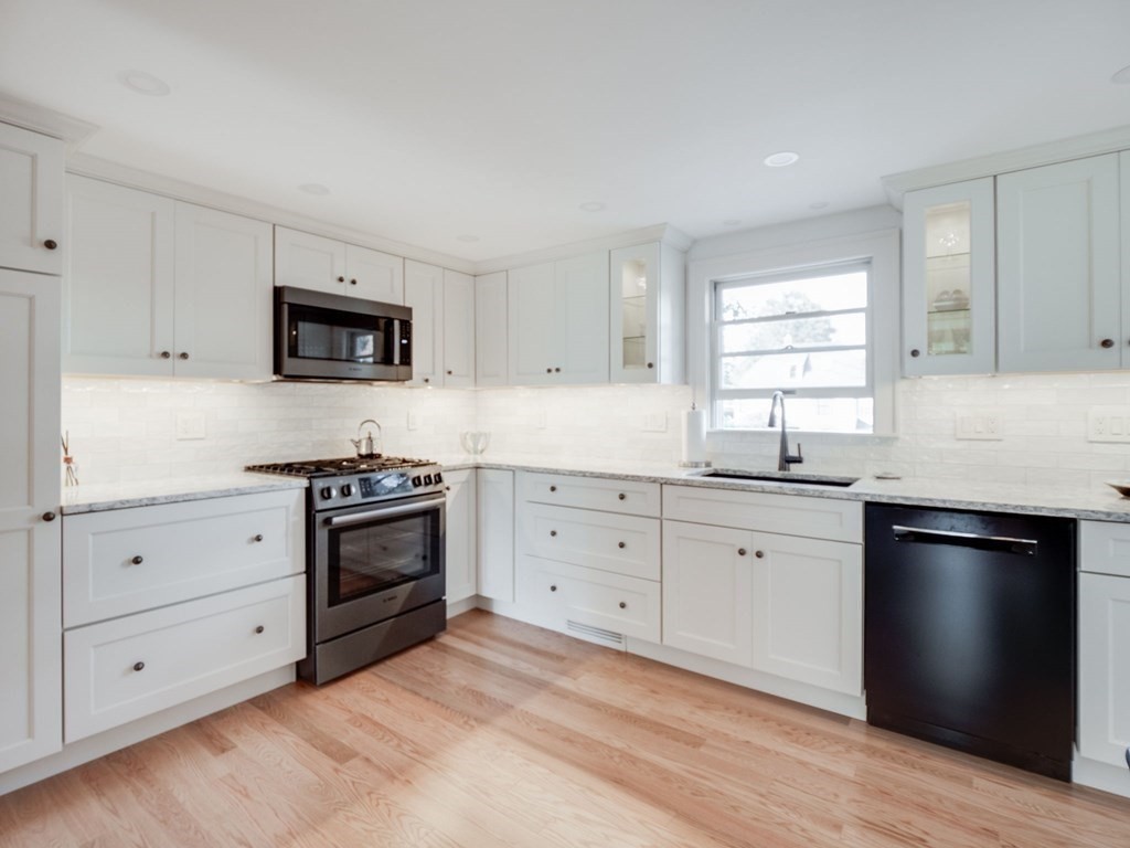 35 Pine Street Melrose, MA 02176 - Photo 6 of 38 a kitchen with granite countertop white cabinets and stainless steel appliances
