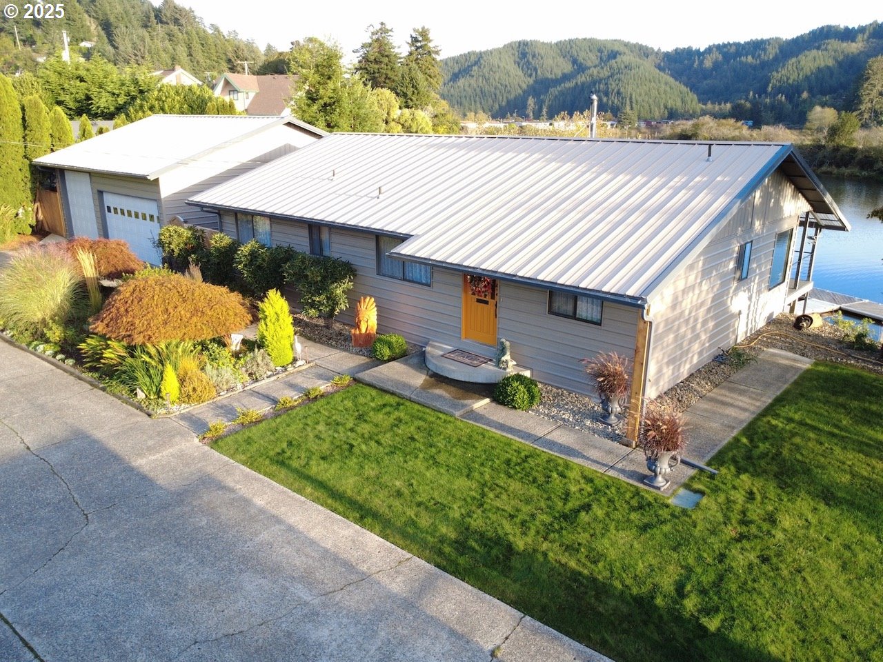 1144 Winchester Avenue Reedsport, OR 97467 - Photo 1 of 47 a aerial view of a house with table and chairs under an umbrella