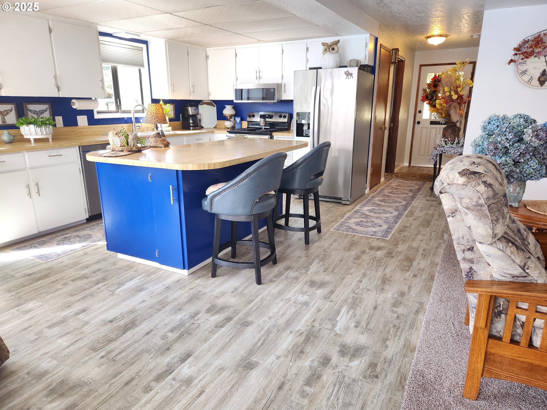 1144 Winchester Avenue Reedsport, OR 97467 - Photo 14 of 47 a kitchen with stainless steel appliances kitchen island granite countertop a refrigerator a stove a sink and white cabinets with wooden floor