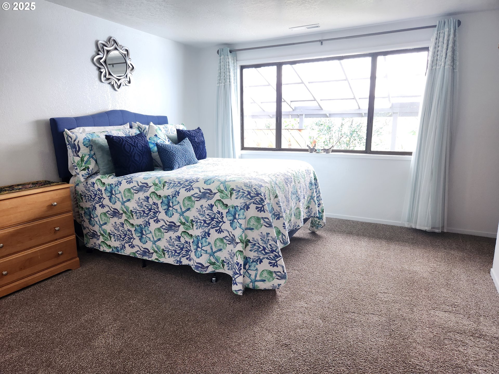 1144 Winchester Avenue Reedsport, OR 97467 - Photo 27 of 47 a bed sitting in a bedroom next to a window