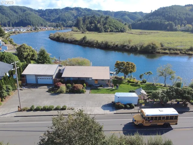 an aerial view of residential houses with outdoor space and river