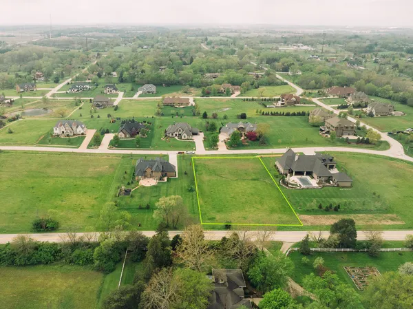 an aerial view of green landscape with trees houses and ocean view