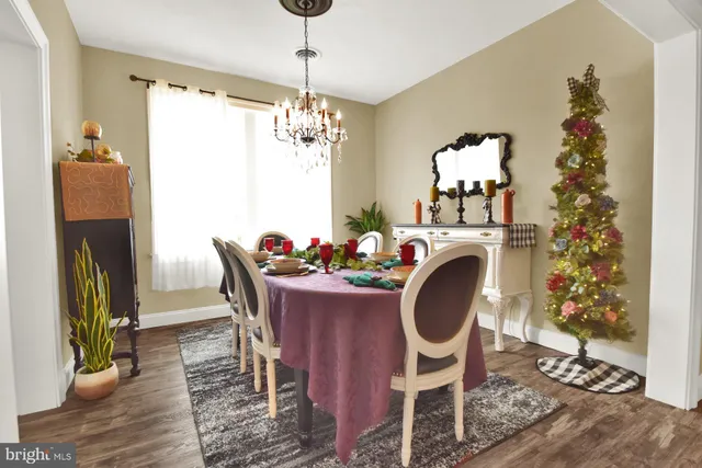 a dining room with furniture a chandelier and wooden floor