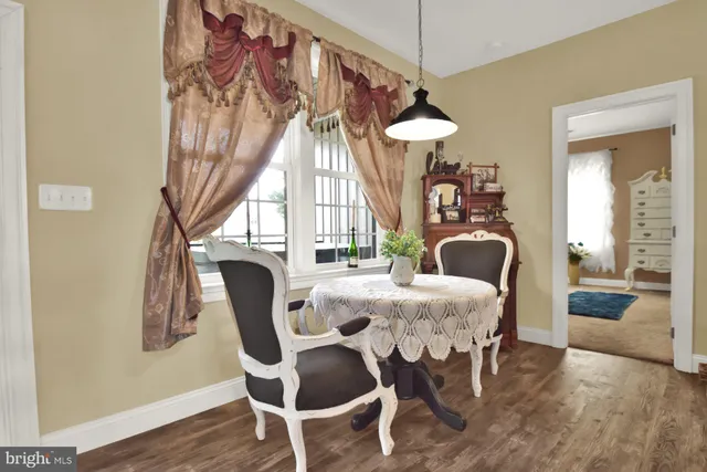 a dining room with furniture a chandelier and wooden floor