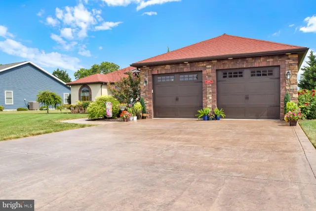 a front view of a house with a yard and potted plants