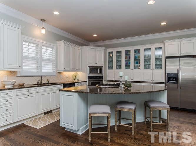 12221 Beestone Lane Raleigh, NC 27614 - Photo 3 of 25 a kitchen with cabinets a counter and chairs