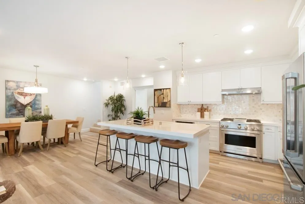 348 Walnut Avenue Carlsbad, CA 92008 - Photo 7 of 20 a kitchen with stainless steel appliances granite countertop a stove top oven a sink dishwasher and a refrigerator with wooden floor