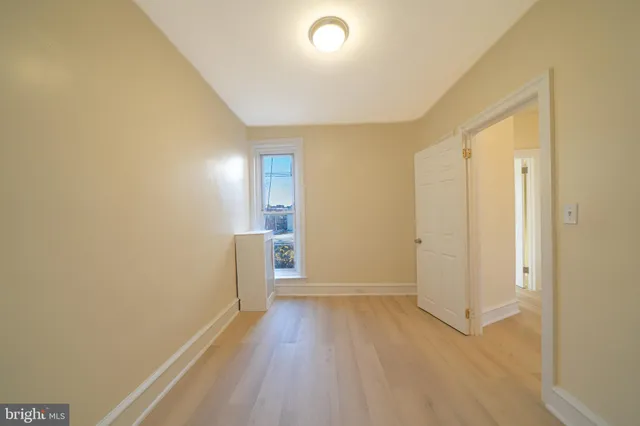 a view of a room with wooden floor and a ceiling fan