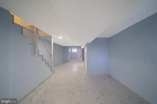 a view of a big room with staircase and white walls