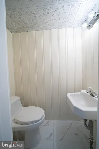 a bathroom with a sink a toilet and mirror