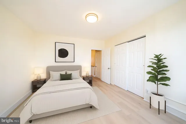a bedroom with a bed and a potted plant