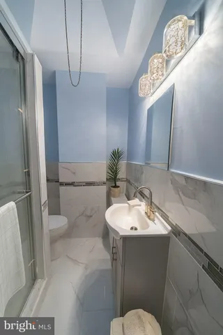 a bathroom with a sink a toilet and a mirror