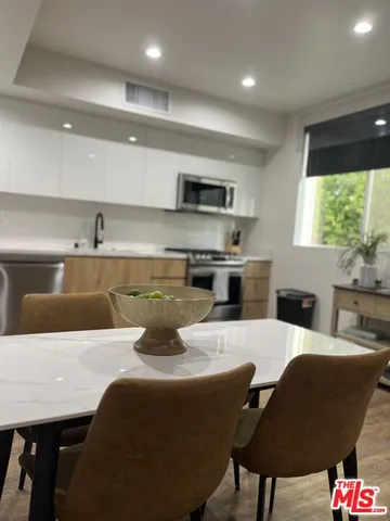 a kitchen with a table chairs refrigerator and microwave