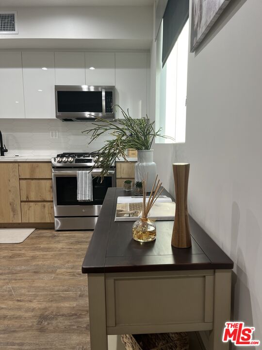124 South Croft Avenue, Unit 101 Los Angeles, CA 90048 - Photo 8 of 22 a kitchen with a sink a stove and chairs