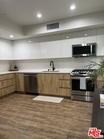 a kitchen with stainless steel appliances granite countertop a sink and a stove