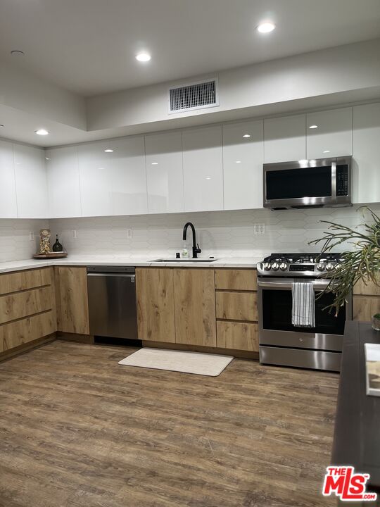 124 South Croft Avenue, Unit 101 Los Angeles, CA 90048 - Photo 9 of 22 a kitchen with stainless steel appliances granite countertop a sink and a stove