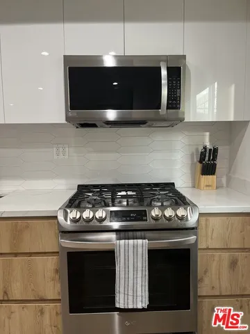 a stove top oven sitting inside of a kitchen