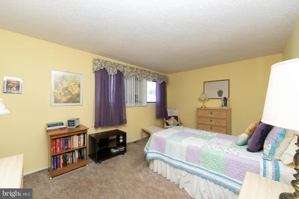 a bedroom with a bed furniture and a book shelf