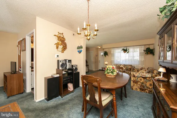 a view of a dining room with furniture and a chandelier
