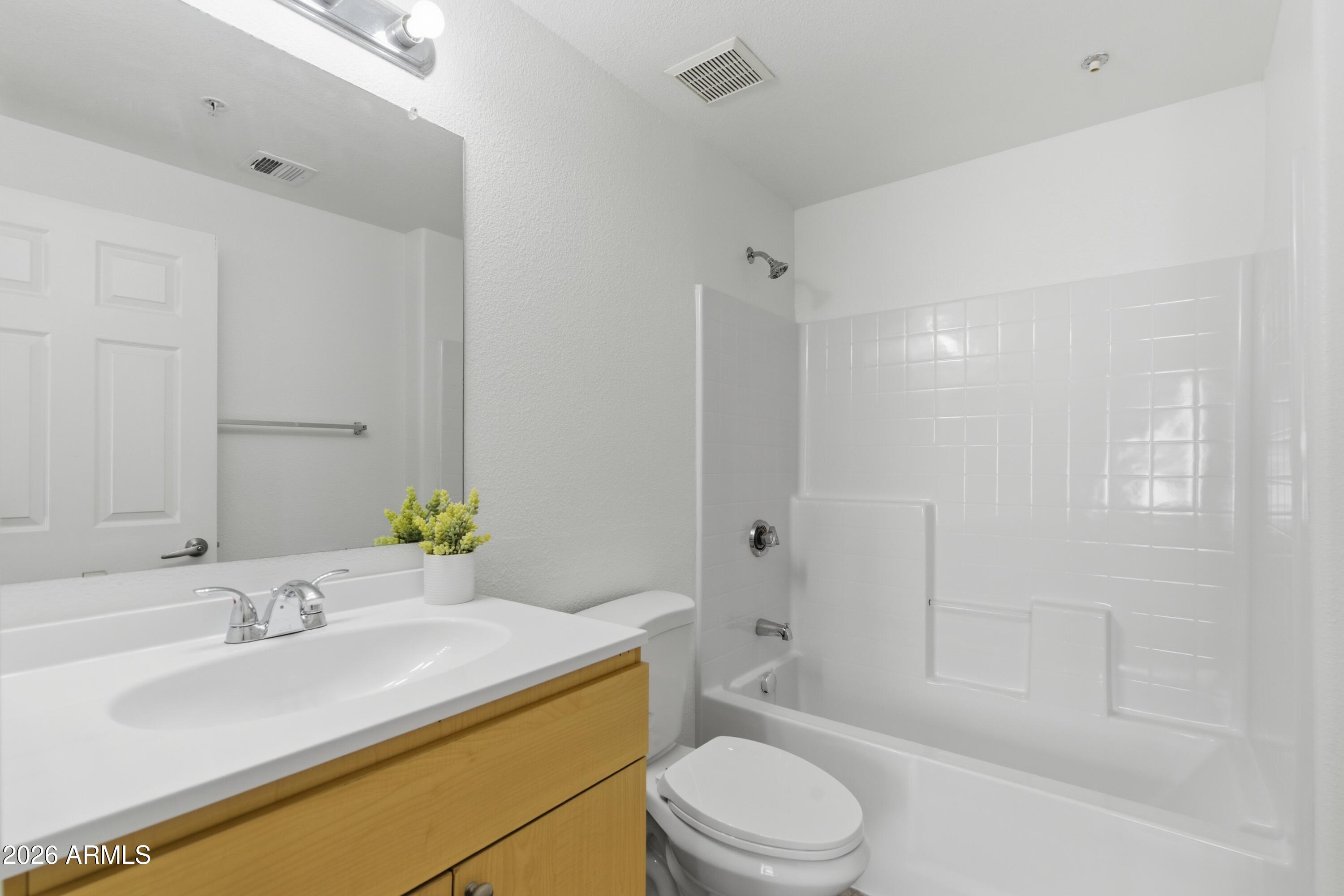 18416 North Cave Creek Road, Unit 3057 Phoenix, AZ 85032 - Photo 12 of 21 a bathroom with a granite countertop sink toilet a mirror and shower