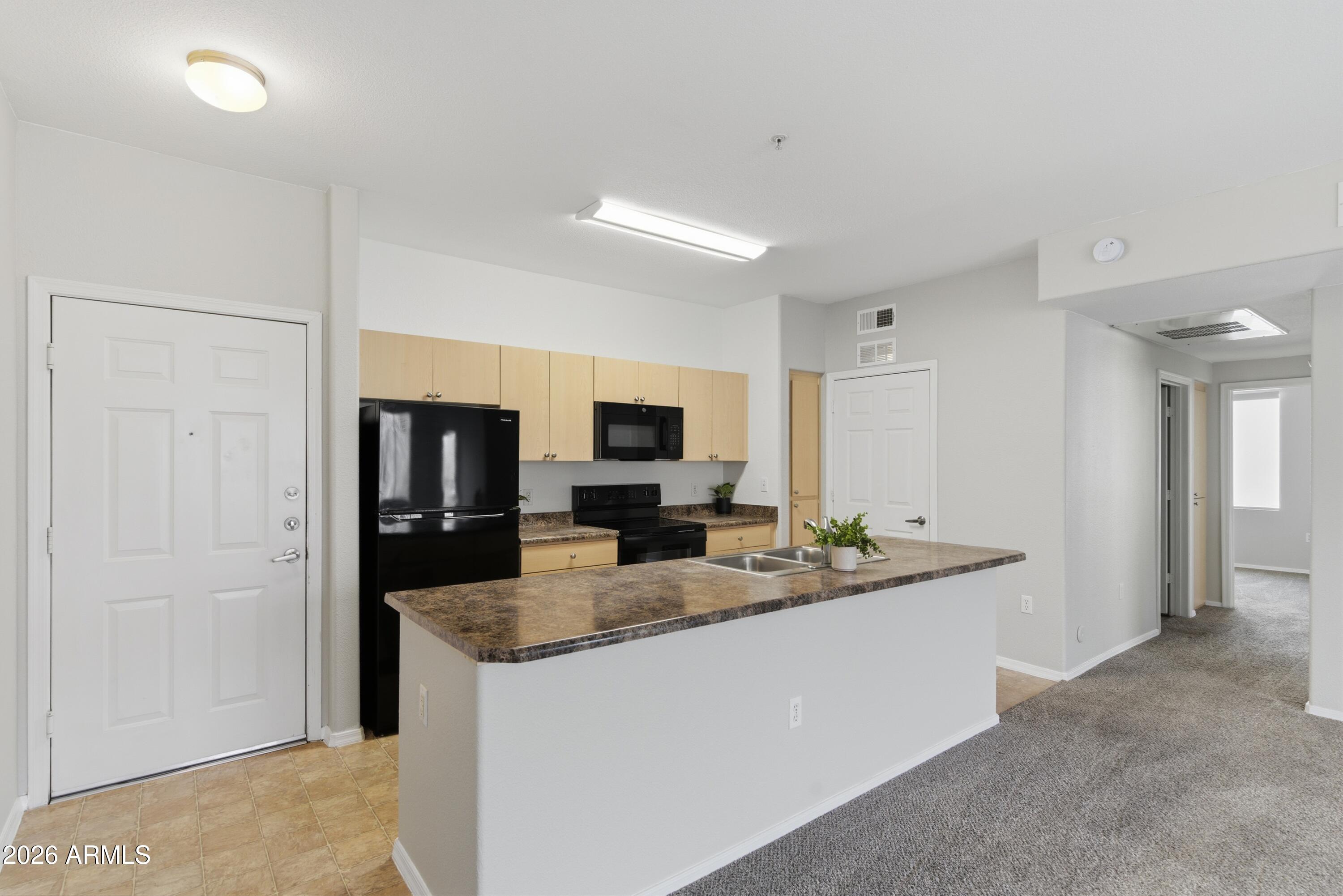 18416 North Cave Creek Road, Unit 3057 Phoenix, AZ 85032 - Photo 7 of 21 a kitchen with sink refrigerator and microwave